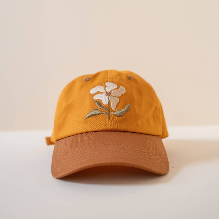Mustard yellow baseball cap with white embroidered flower on the front panel
