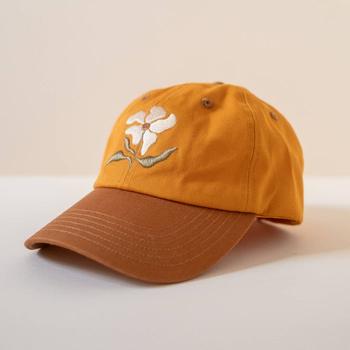 Orange cap with white flower embroidery on the front