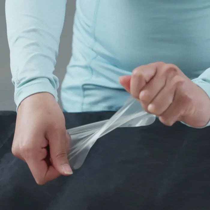Gear Aid Tenacious flex patches being stwisted in someones hands to show the stretch