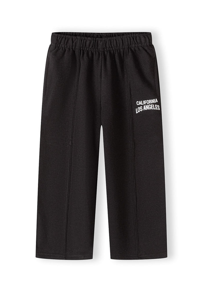 Black loose fit jogging trousers for girls, featuring an elastic waistband and logo detail.