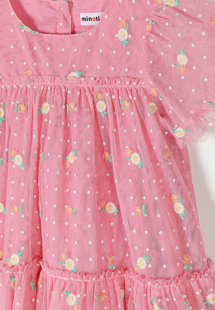 Detail of a girls' pink floral embroidered tulle dress with short sleeves and polka dots.