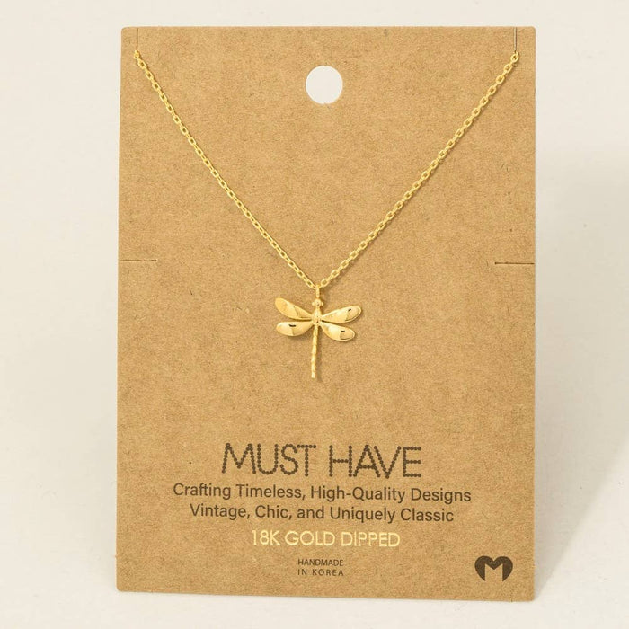 Gold dipped dragonfly pendant necklace displayed on brown craft card