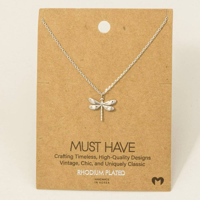 Rhodium plated dragonfly pendant necklace displayed on brown craft card