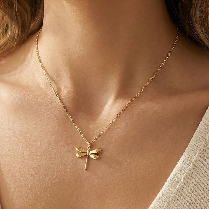 Gold dipped dragonfly pendant necklace worn on a model's neckline