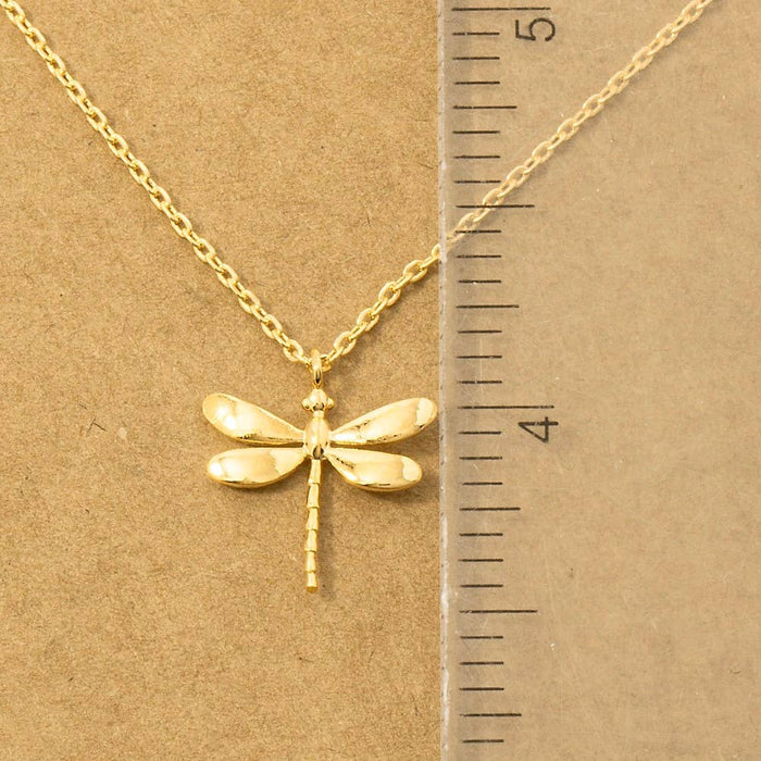 Close-up of gold dragonfly pendant necklace with chain and scale ruler for size