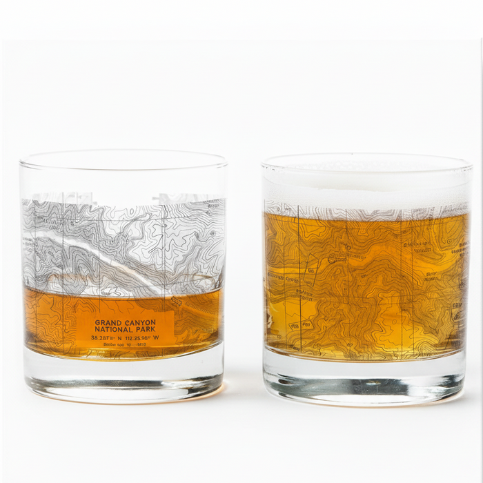 Two whiskey glasses featuring Grand Canyon National Park topographic map designs, one partially filled with amber liquid.