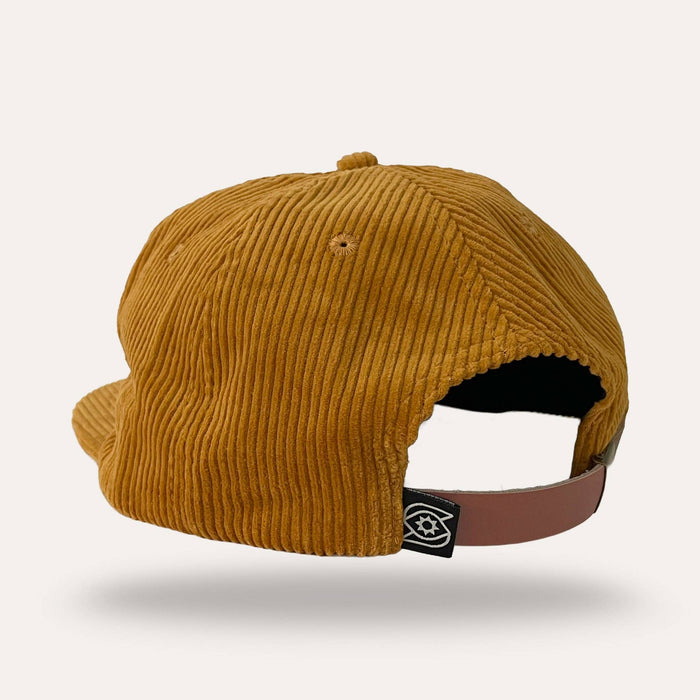 Mustard corduroy flatbrim hat with a brown leather strap and buckle