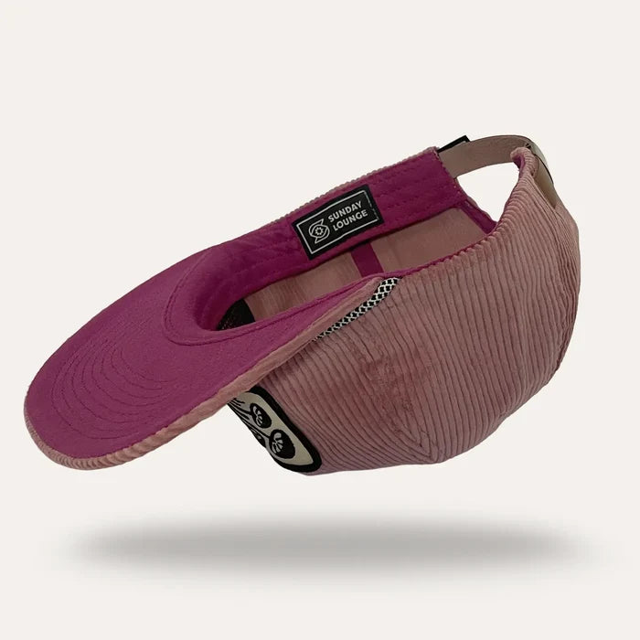 Magenta pink corduroy flatbrim hat with a Sunday Lounge patch on the front and visible interior lining