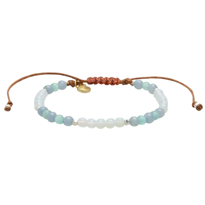 Beaded freshwater pearl bracelet with pale blue and white beads on a white adjustable cord