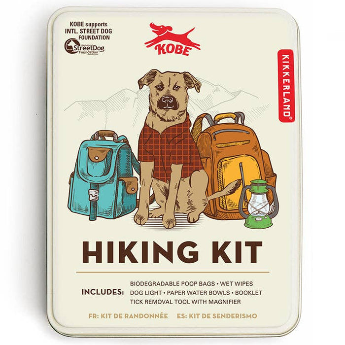 Hiking Kit tin shows a dog in a red plaid shirt between teal and orange backpacks and a lantern.