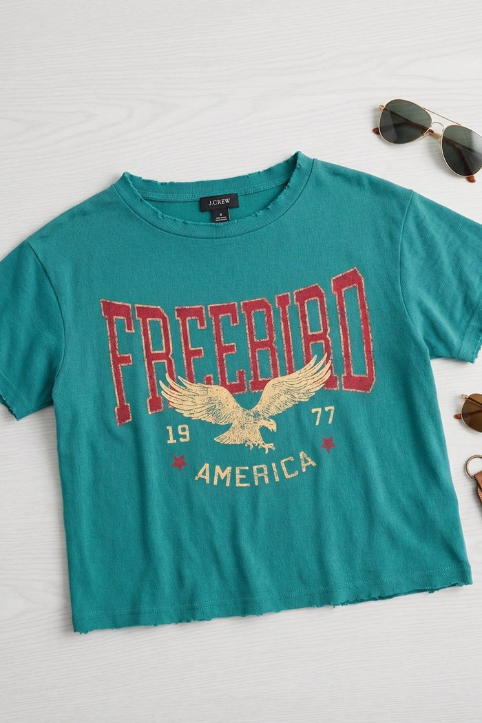 Women's teal vintage Free Bird America graphic tee featuring an eagle design, faux cropped silhouette, relaxed fit, and soft cotton fabric.