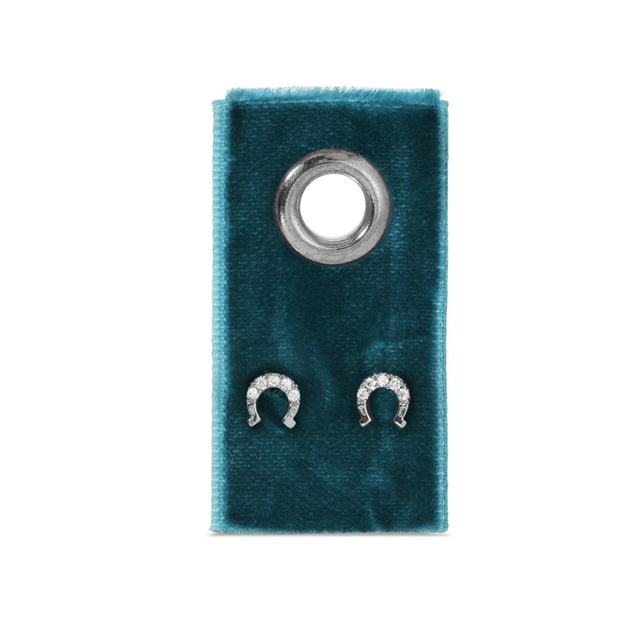 Teal velvet jewelry display with a metal grommet and two diamond horseshoe stud earrings