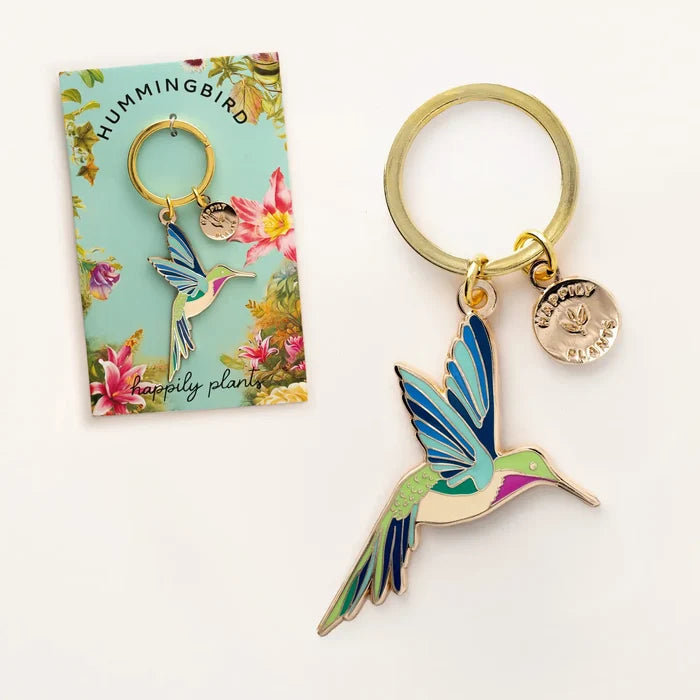 Hummingbird keychain with blue green enamel bird charm and a small round pendant on a floral turquoise card