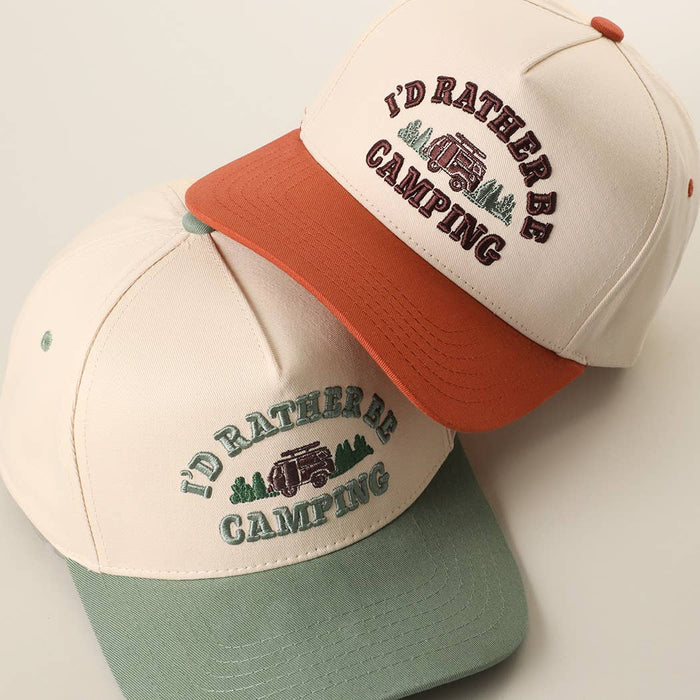 Two beige trucker hats stacked, one with an orange brim and one with a sage green brim, embroidered I'D RATHER BE CAMPING.