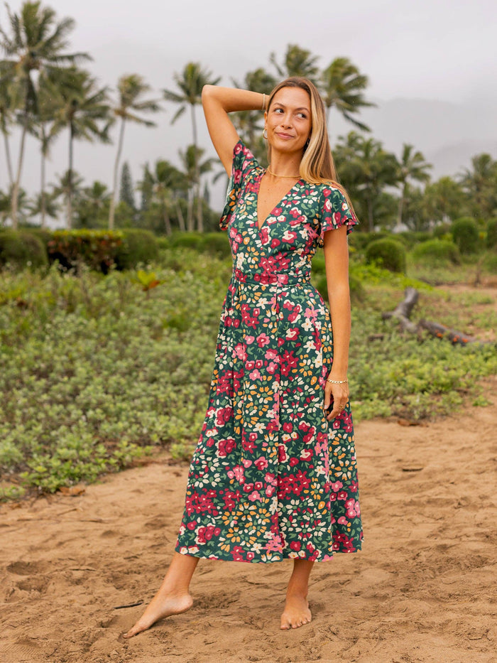 Model wearing Isla Dress in a green floral print outdoors.