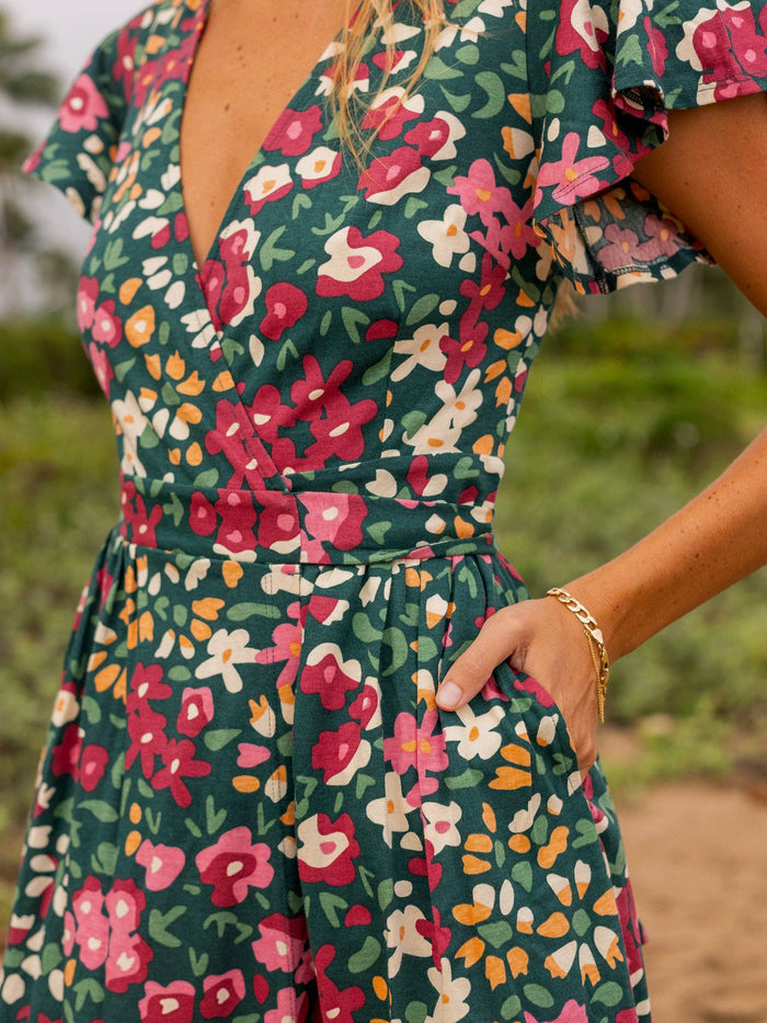 Isla Dress wrap neckline close up showing a bold wildflower print on emerald fabric