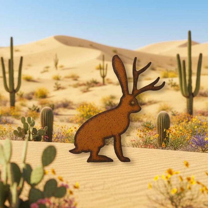 Rusty metal jackalope magnet posed in a desert scene with cacti in the background