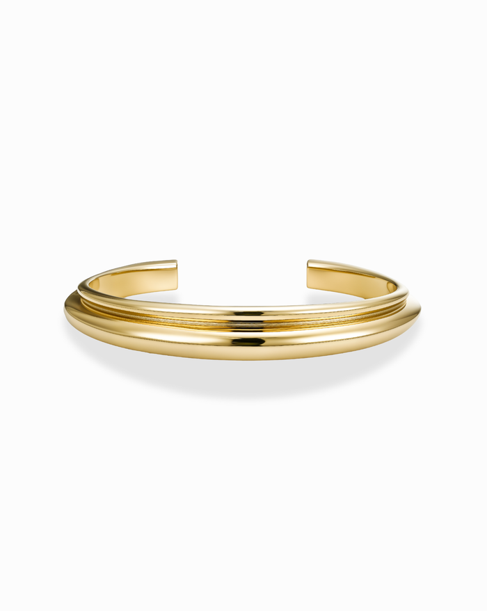 Gold double dome cuff bracelet on a white background