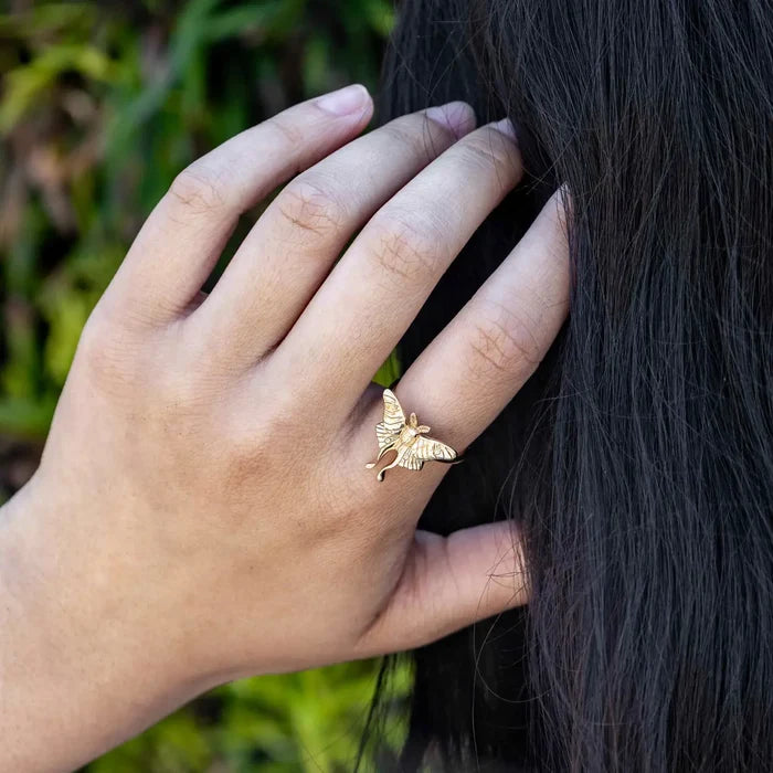 Close-up of a hand wearing a gold Luna Moth ring
