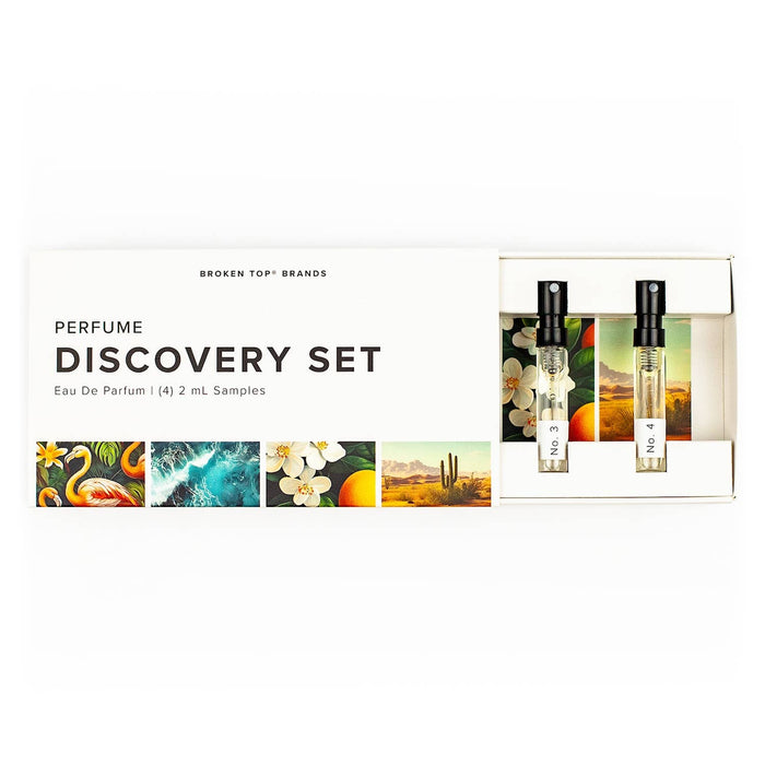 Opened perfume discovery set box with two spray vials visible on the right and colorful art panels along bottom.
