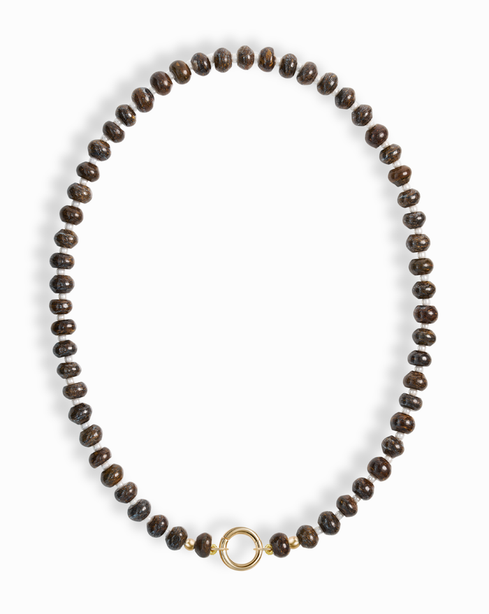 The Macey Gemstone Necklace by Mod + Jo features evenly spaced dark brown round beads and a simple 14k gold-plated circular clasp at the center, displayed on a white background.