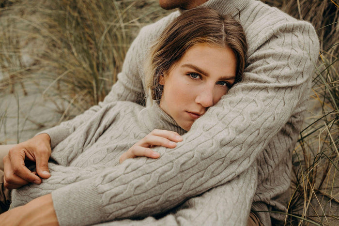 a couple wearing lichen cable sweaters