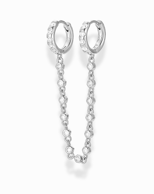Silver hoop channel set cz earrings with a bezel cz chain extension between the two hoops on a white background