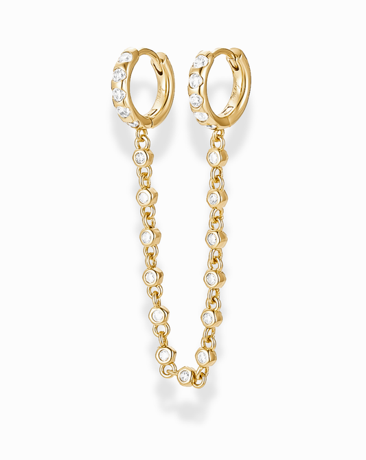 Gold hoop channel set cz earrings with a bezel cz chain extension between the two hoops on a white background