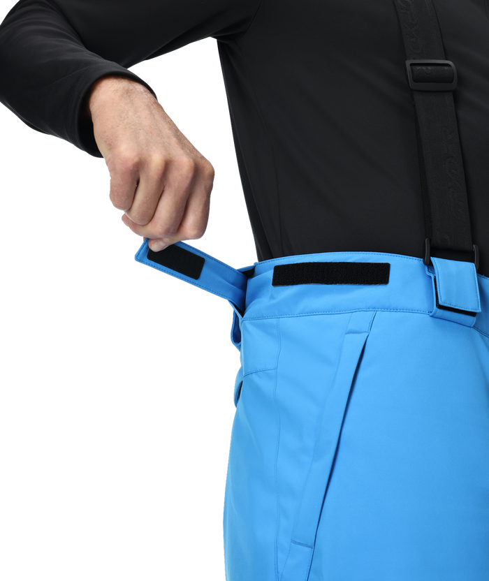 Person wearing black jacket and blue pants with a white background