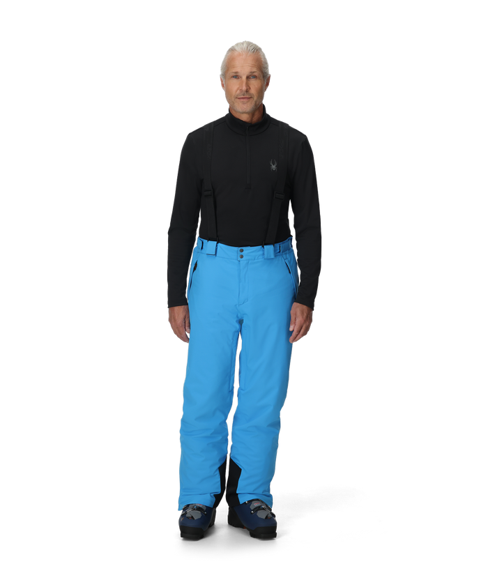 Person wearing a black top and blue pants on a white background