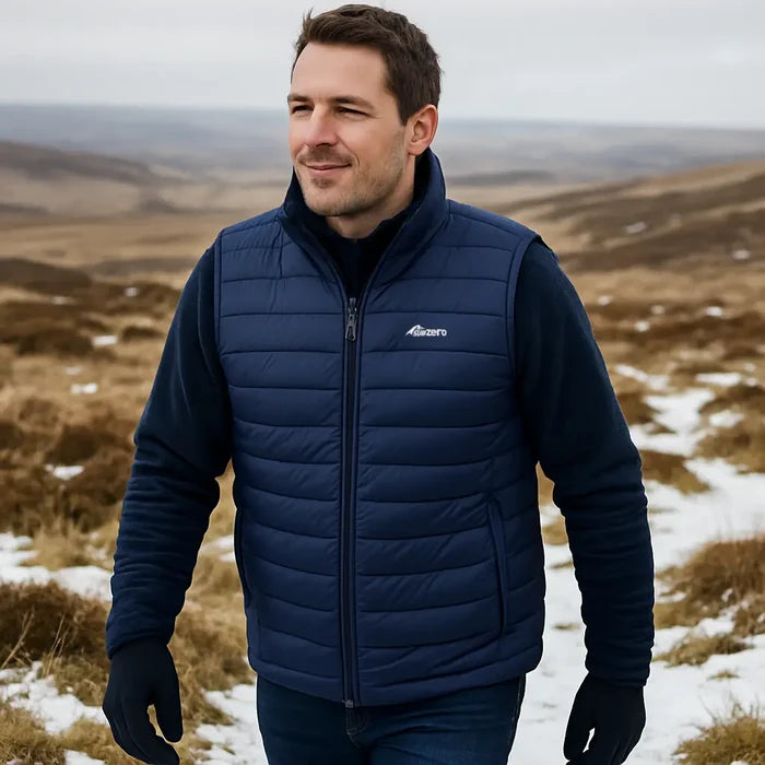 A man wearing a Sub Zero mens lightweight sunthetic insulated body warmer with Factor 2 gloves whilst walking in the snow.