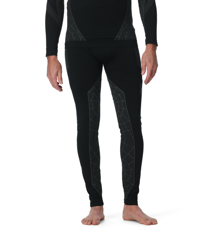 Person wearing black thermal leggings with geometric patterns on a white background