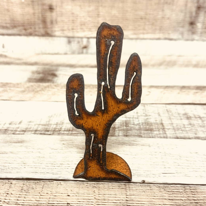 Mini rusted metal cutout of a saguaro cactus on a small curved base with white highlights