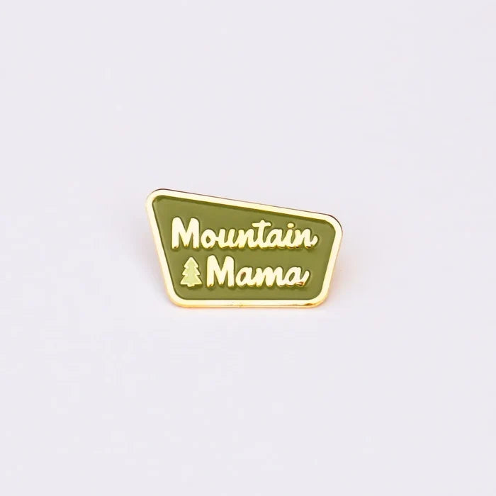 Green enamel Mountain Mama pin with gold border and pine tree icon