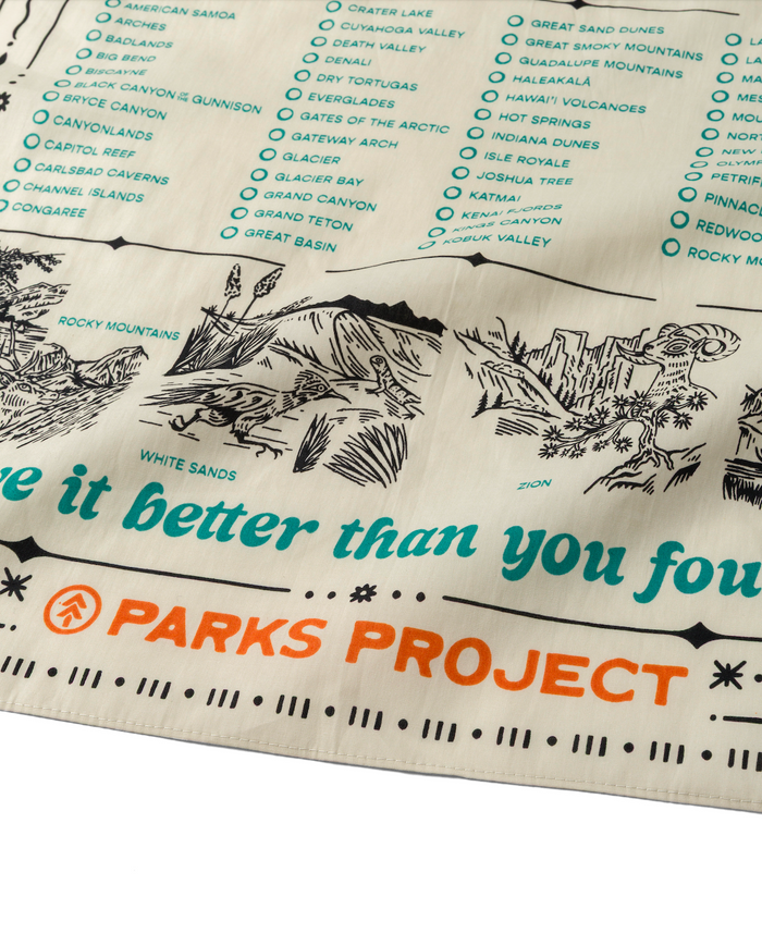 Close up of the National Park Naturalist Bandana showing turquoise park names and illustrated landscape with Parks Project branding.