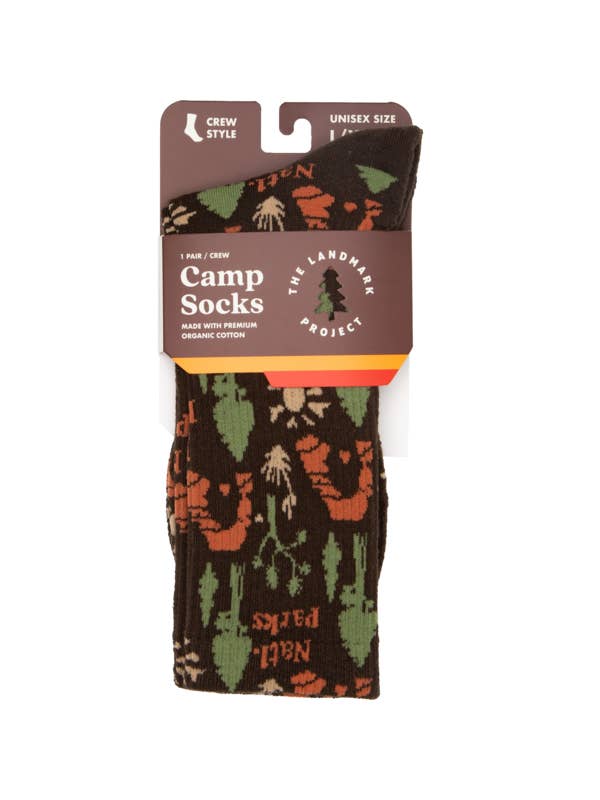 Dark brown Camp Socks with a green and orange forest print on retail packaging