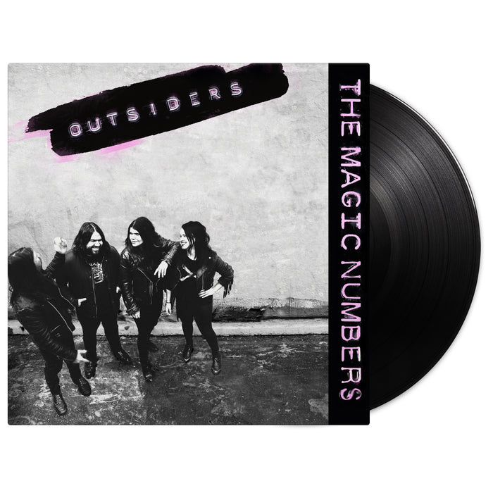 A black vinyl record partially in its cover. The cover shows four people in black outfits against a wall. “OUTSIDERS” is written in purple at the top, with “The Magic Numbers” and Rebel Song also in purple on the right. Brand: The Magic Numbers.