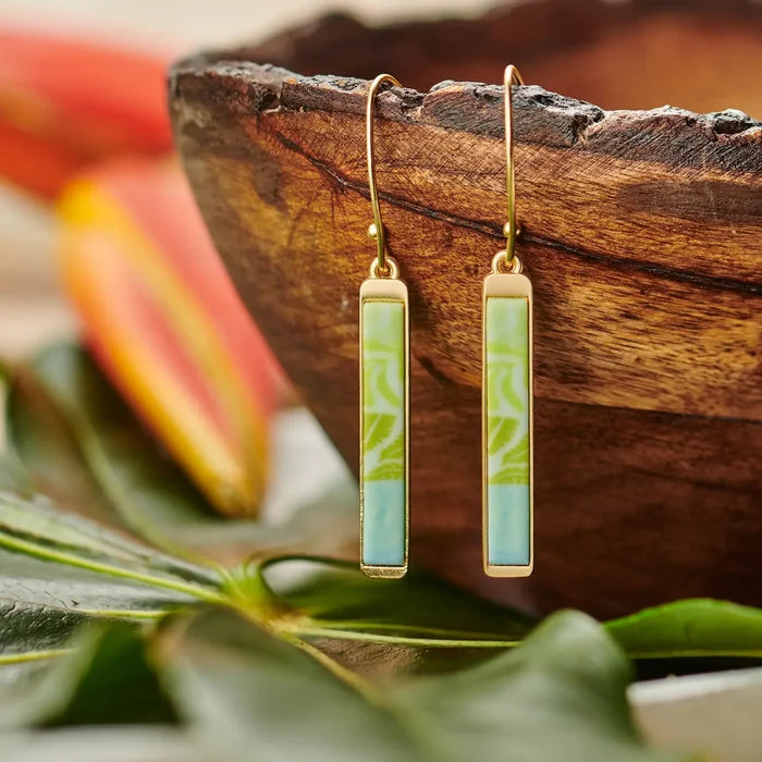 Close up Palm Beach Reversible Mini Bar Earrings gold framed turquoise patterned bars hanging from gold hooks against wood background