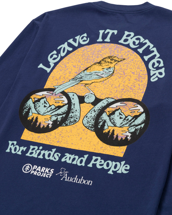 Navy Parks Project X Audubon long sleeve tee back graphic with a yellow circular design featuring a bird on bicycle wheels and the Love It Better for Birds and People slogan