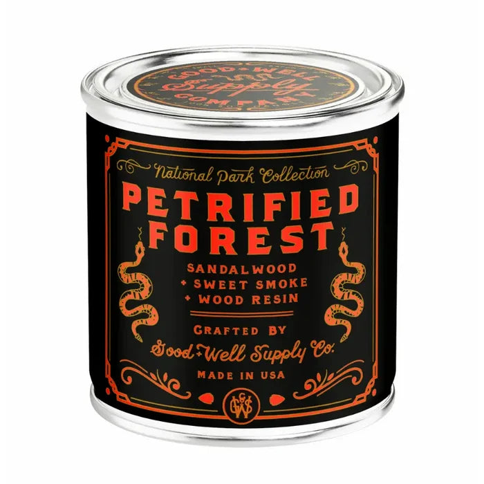 Petrified Forest National Park candle in a half pint tin with a black label and orange text including sandalwood sweet smoke and wood resin
