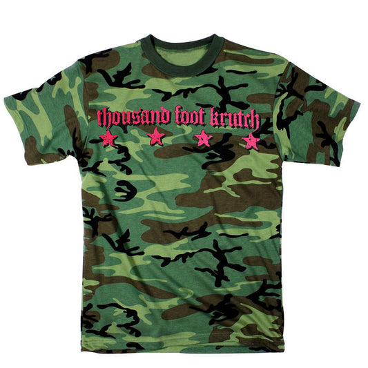 A youth small, short-sleeve camouflage T-shirt from Thousand Foot Krutch features thousand foot krutch in pink stylized text across the chest above four pink stars.
