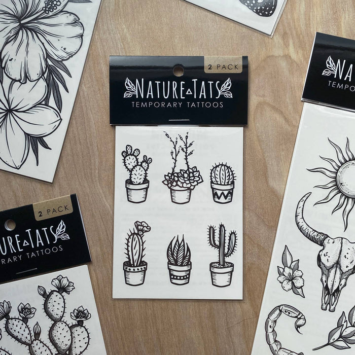 Three potted cactus illustrations on a white temporary tattoo sheet