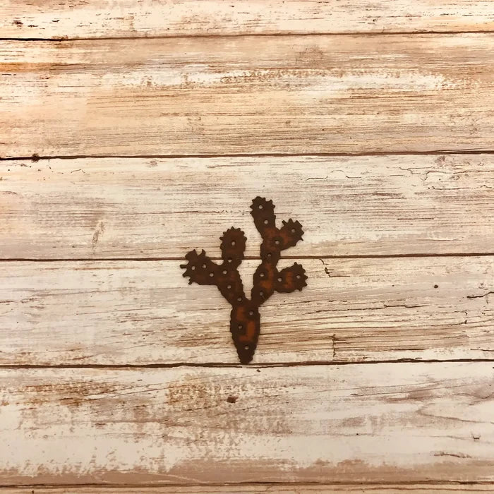 Rusty cactus shaped magnet with multiple arms resembling a prickly pear on weathered wood background