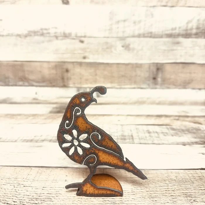 Floral rust metal quail standee with decorative cutouts on a small base in front of a wooden backdrop