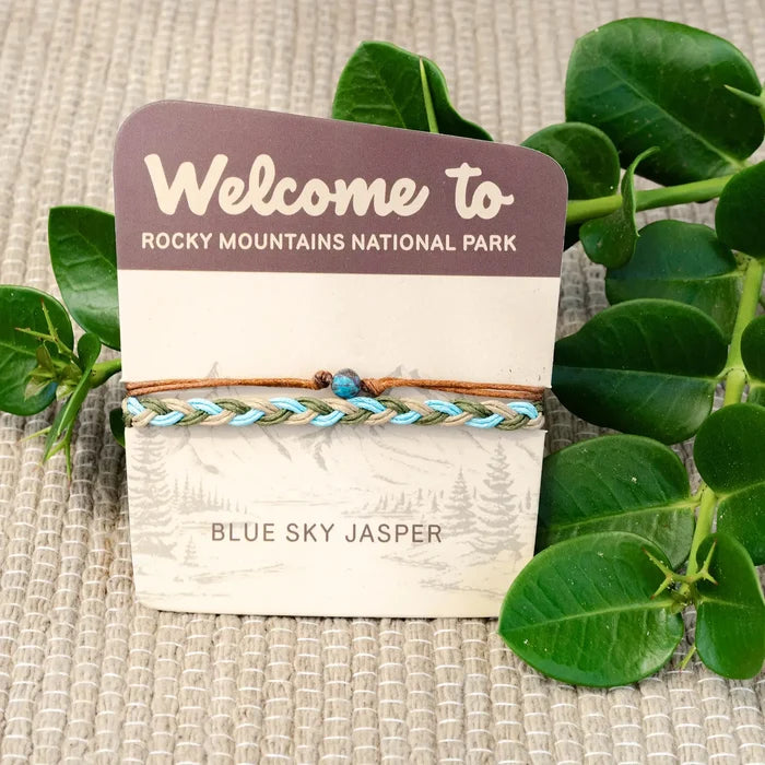 Blue Sky Jasper bracelet with turquoise blue, olive, and tan braided cords and a blue central bead on packaging