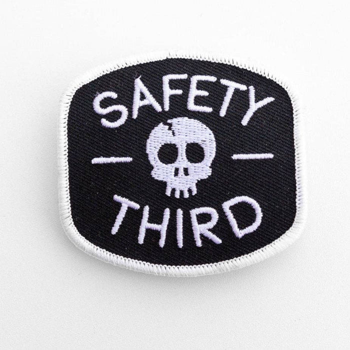 Circular black patch with white skull and the words Safety Third