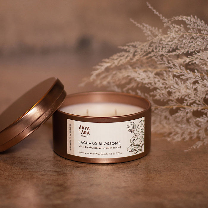 Saguaro Blossoms candle in copper tin with lid off and label featuring a cactus illustration