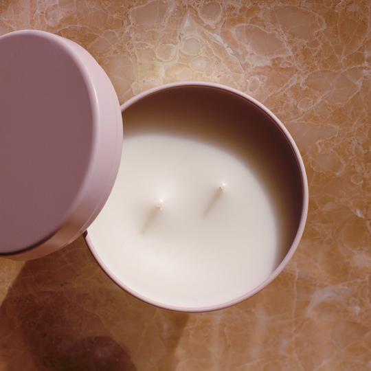 Two wick white wax candle in a pale pink tin viewed from above with lid to the side.
