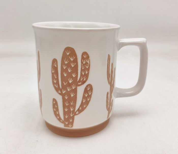 White ceramic mug with tan cactus silhouettes wrapping around the side