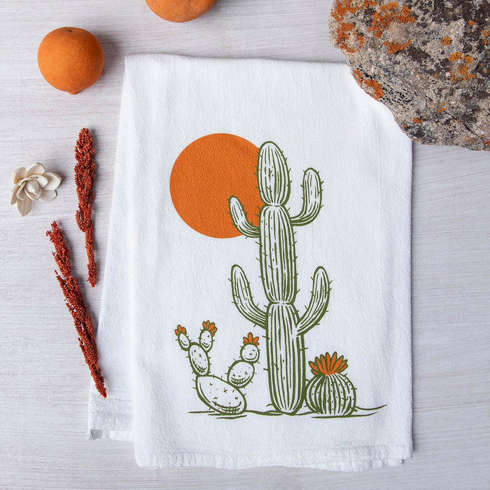 White tea towel featuring a tall cactus and orange sun graphic.